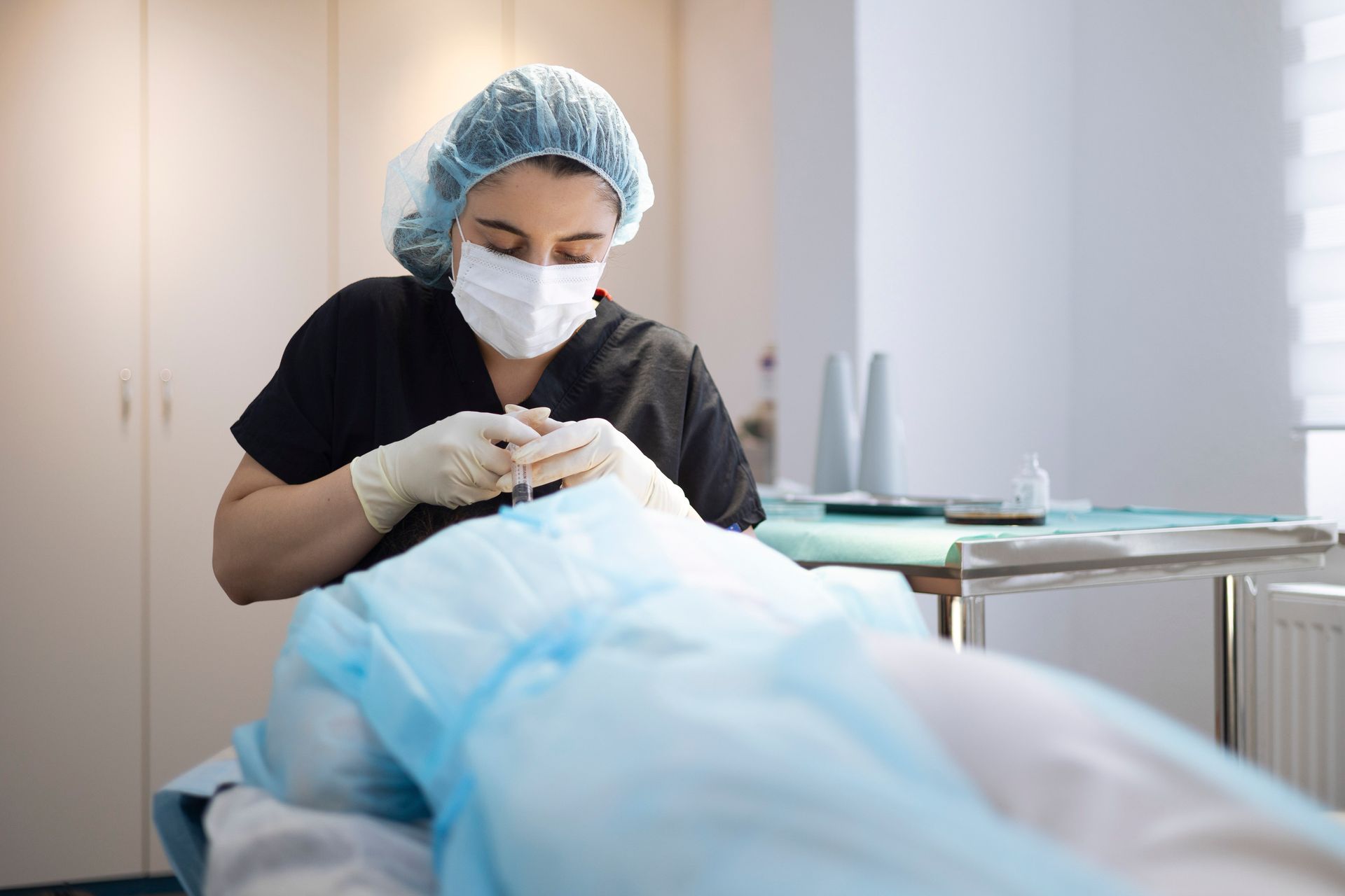 Zahnarzt in Schutzkleidung untersucht einen Patienten auf einem Zahnarztstuhl