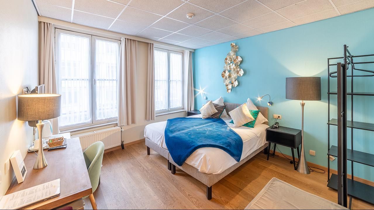 A reception area with a wooden counter and chairs of The Bank Hotel