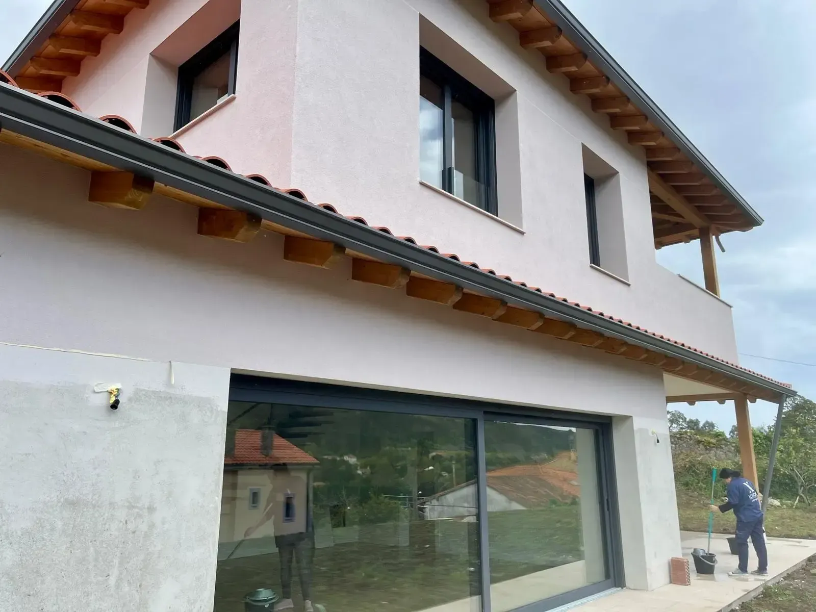 Casa de dos pisos con exterior de estuco rosa claro