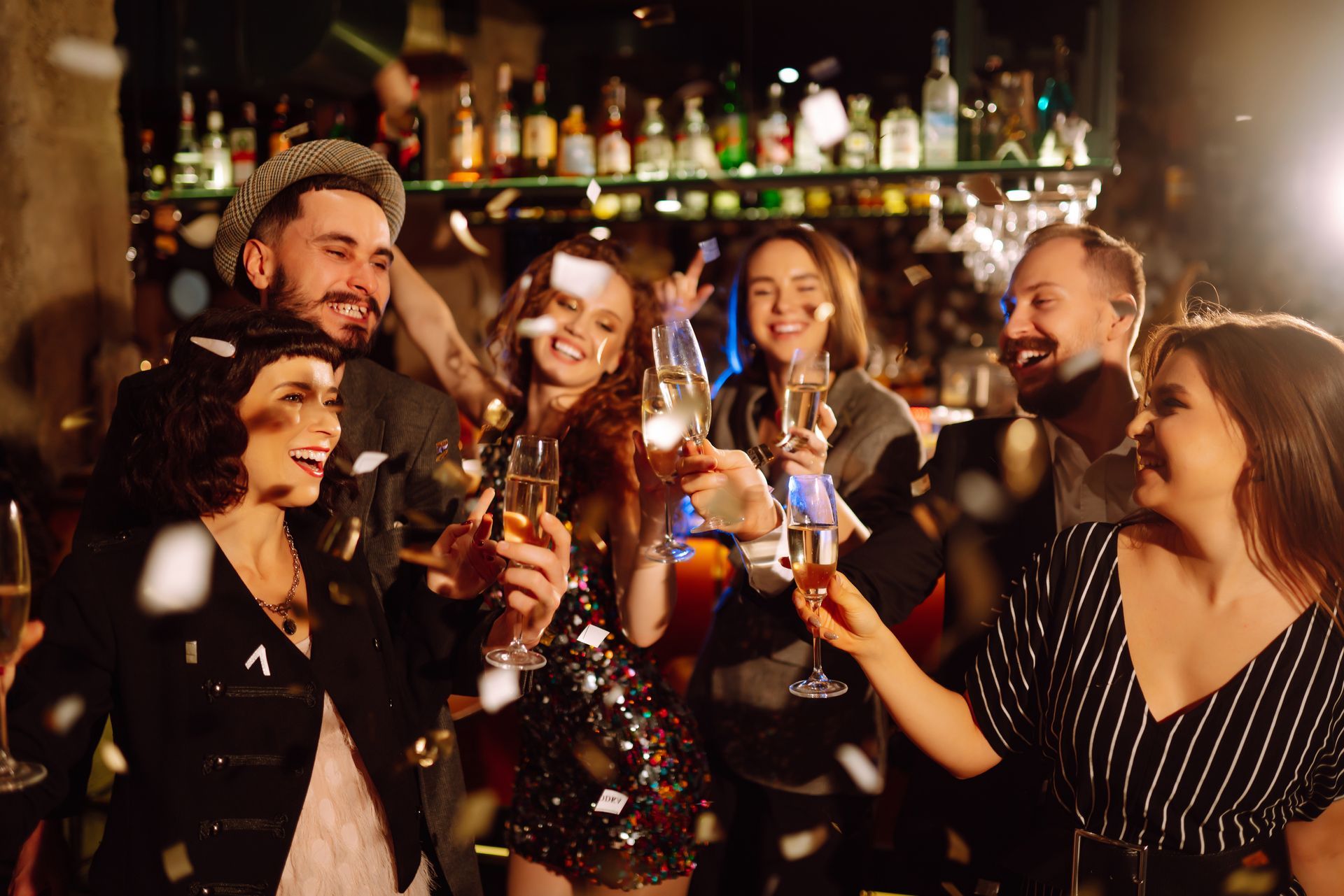 Des amis trinquent et rient dans un bar animé aux lumières colorées
