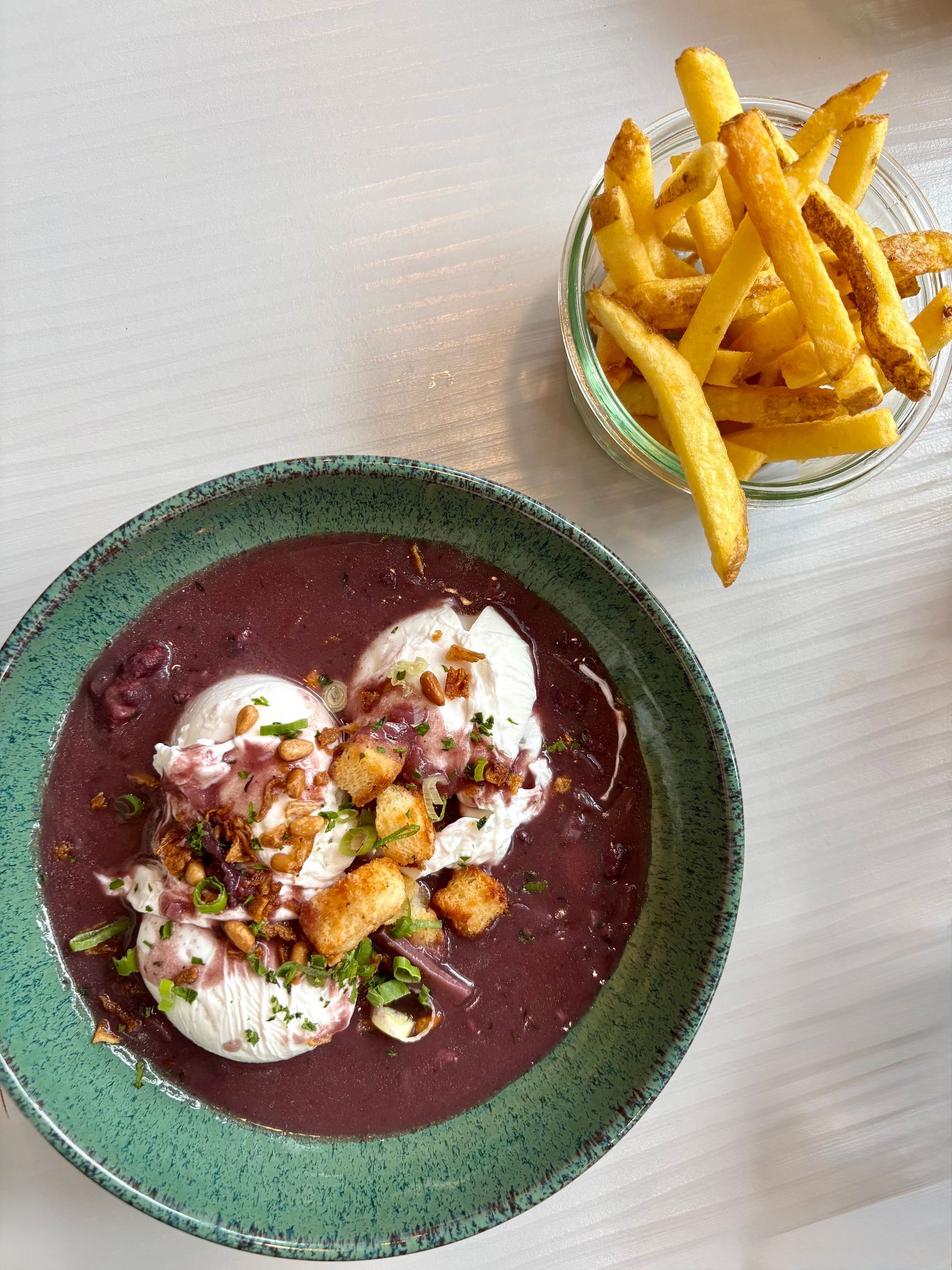 Œufs meurette en sauce dans un bol, accompagnés de frites