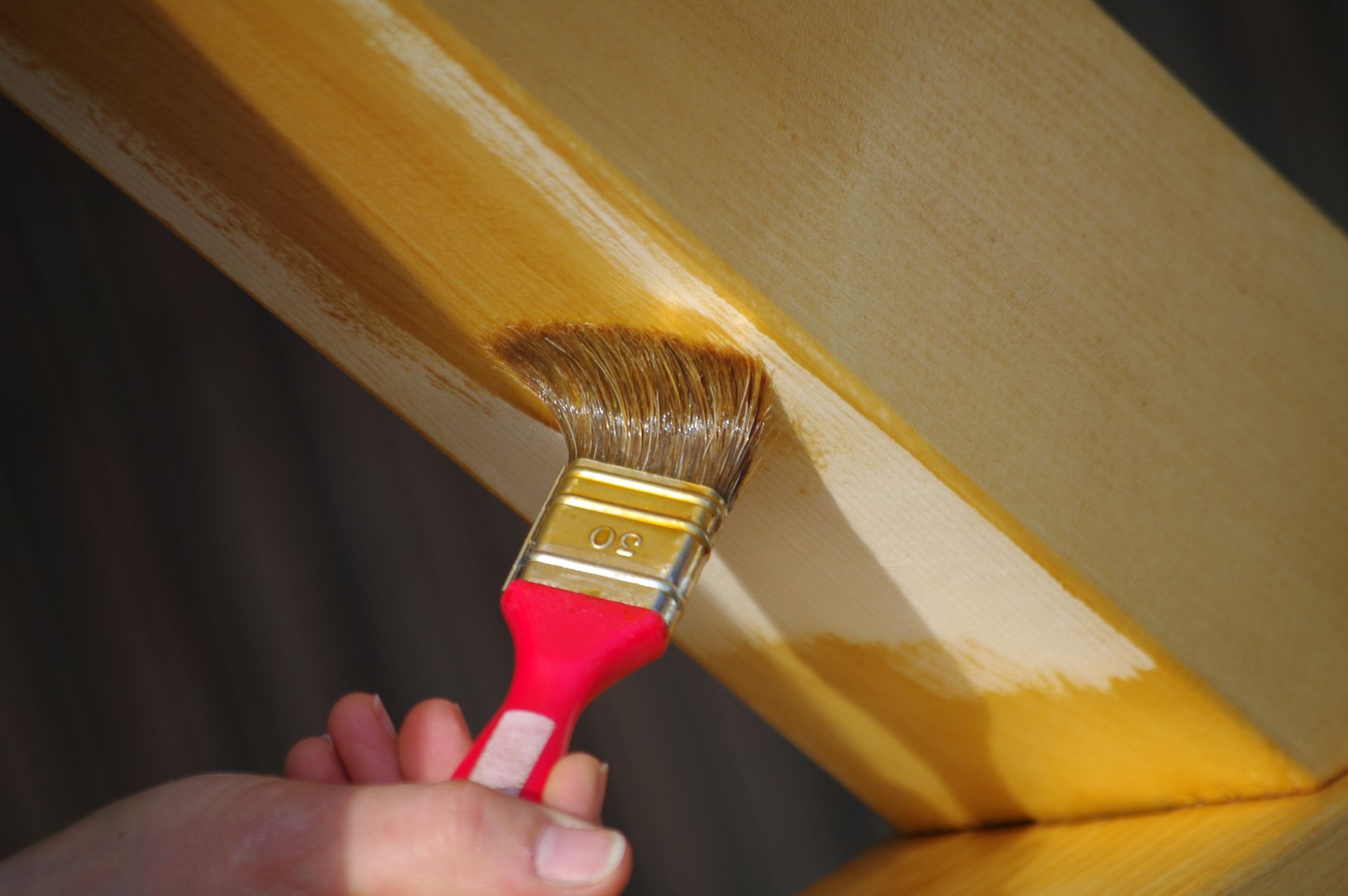 Peinture à la main d'une surface en bois jaune au pinceau