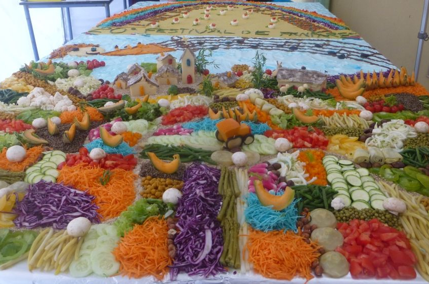 Sur une table des légumes de toutes les couleurs posés en lignes et formes géométriques représentant un paysage