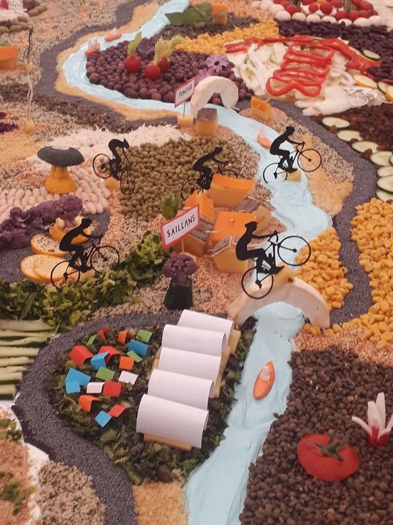 Sur une table des légumes de toutes les couleurs posés en lignes et formes géométriques représentant un paysage