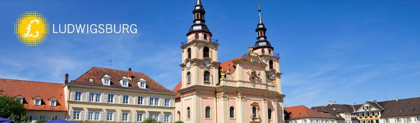 Marktplatz mit einer Barockkirche, farbenfrohen Gebäuden und dem Ludwigsburg-Wappen links