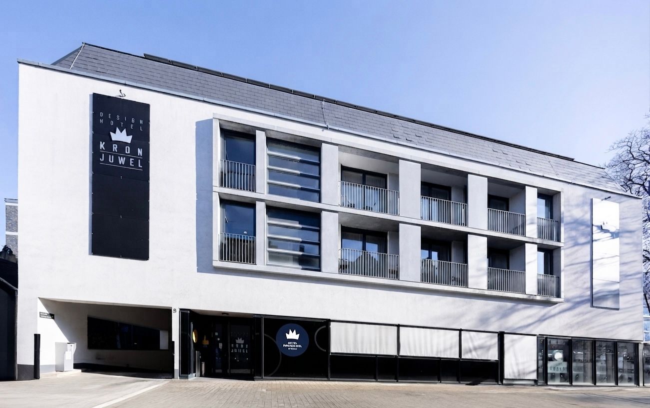 Modernes weißes Bürogebäude mit großen Fenstern und dunklen Akzenten, von außen betrachtet
