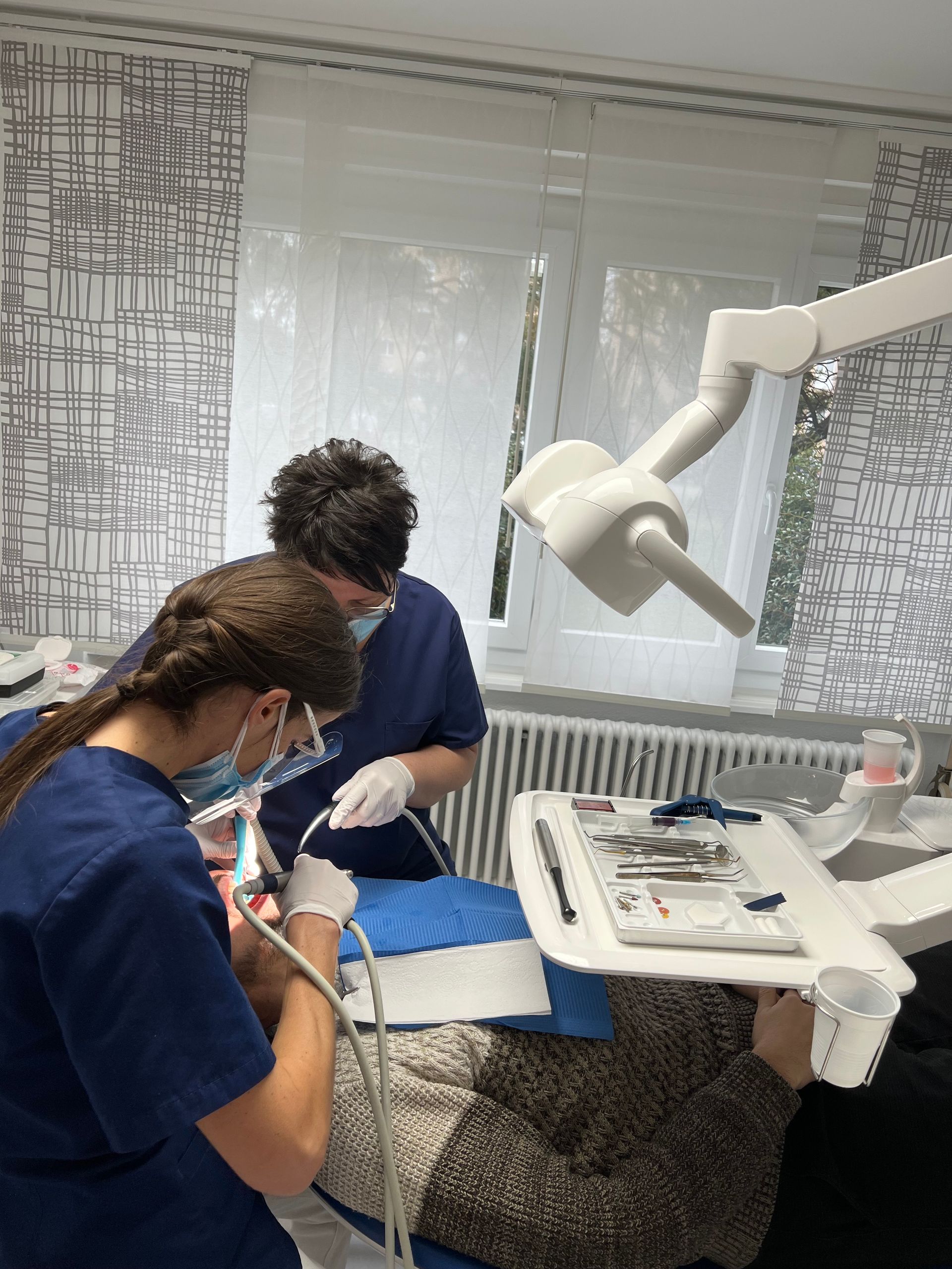 Une dent, une brosse à dents, un stéthoscope et des instruments dentaires sur fond bleu.