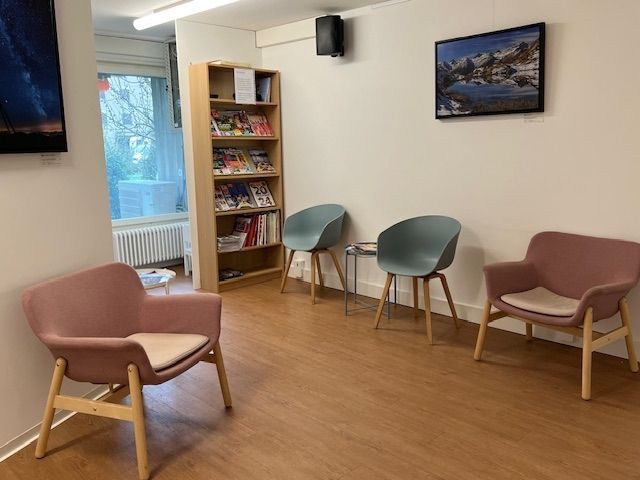Une salle d'attente avec des chaises et une bibliothèque