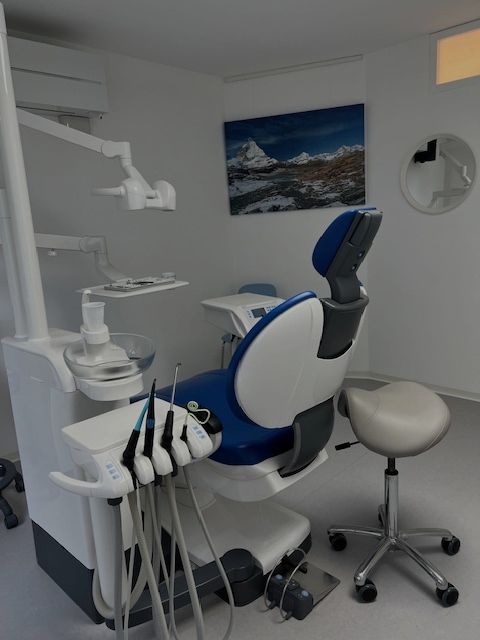 Une chaise dentaire bleue et blanche dans un cabinet dentaire