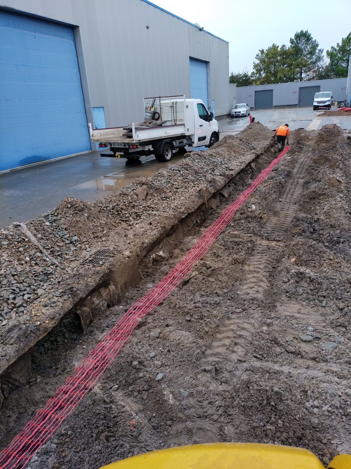 Une tranchée et des tuyaux rouges.