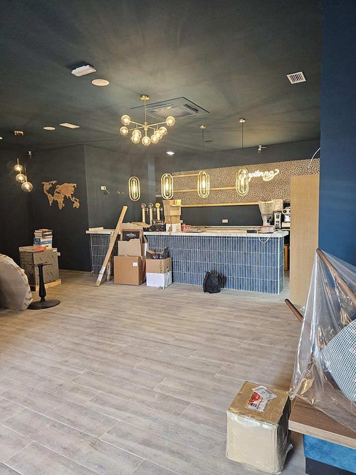 Una gran habitación vacía con suelo de madera y un mostrador.