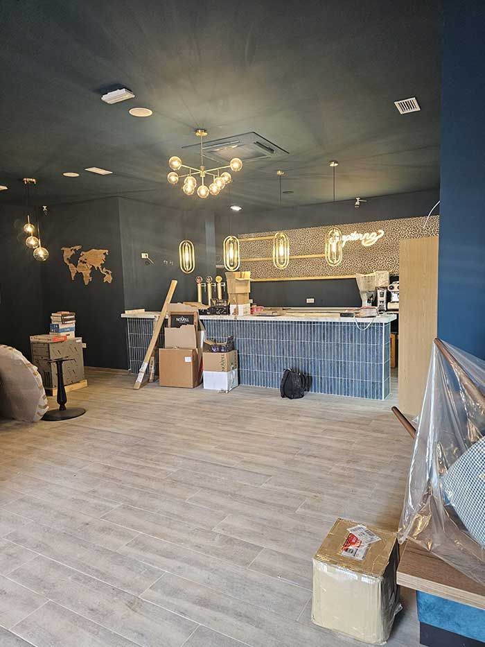 Una gran habitación vacía con suelo de madera y cajas en el suelo.