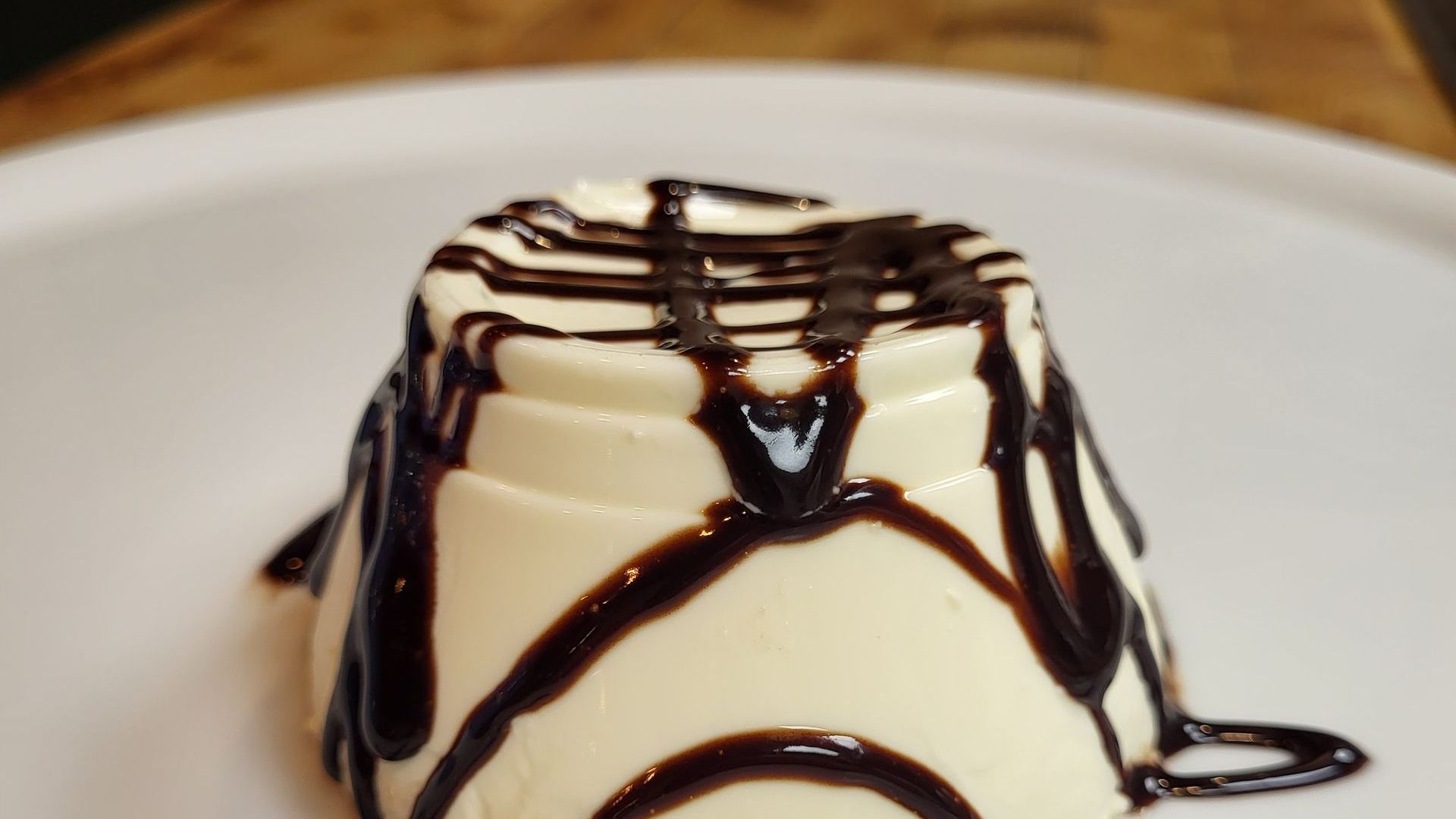 Une panna cotta avec un coulis de chocolat