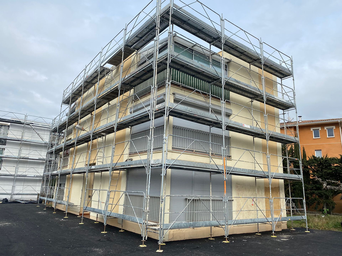 Échafaudages devant un bâtiment jaune