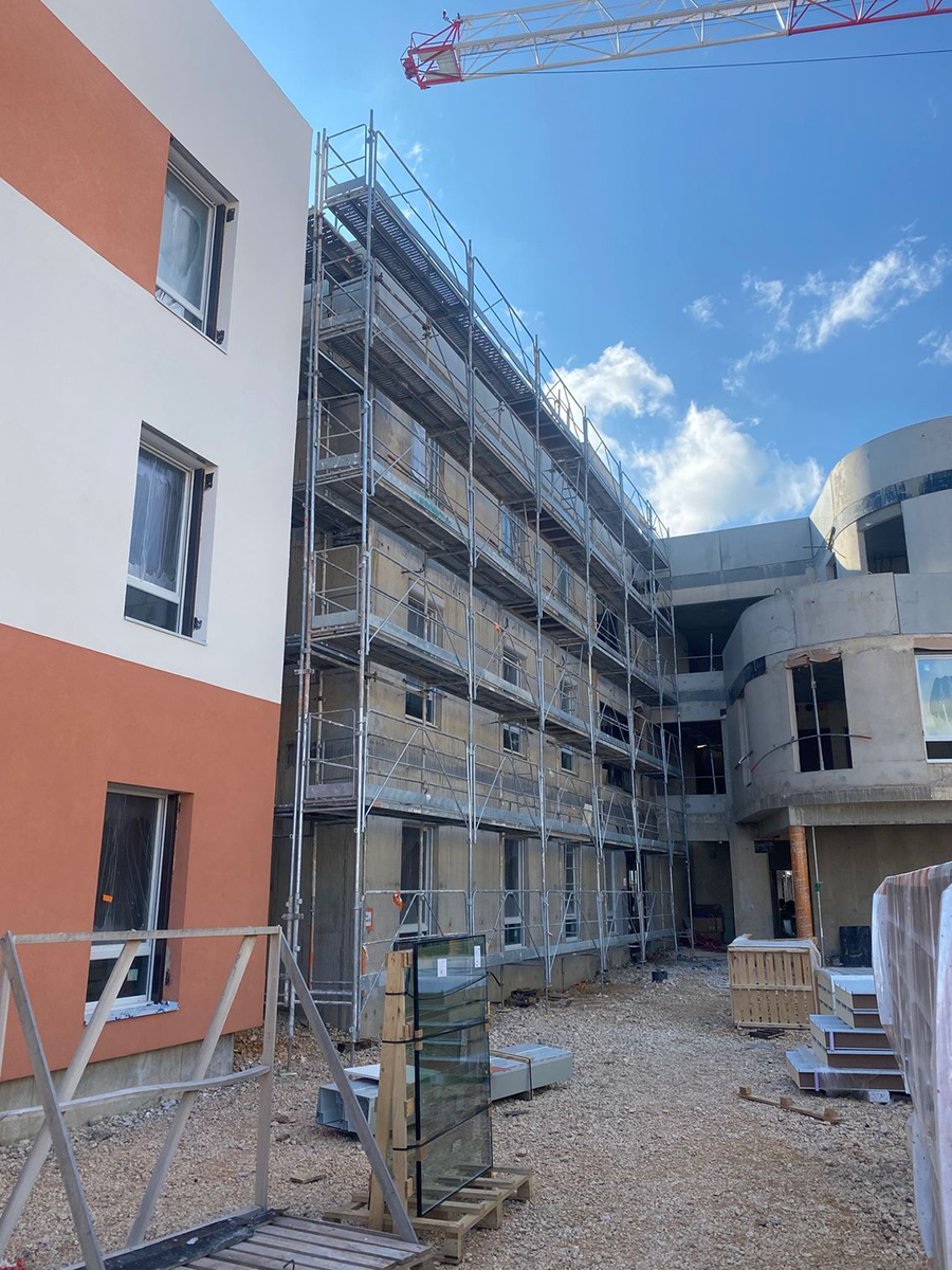 Échafaudage à côté d'un mur rouge et blanc