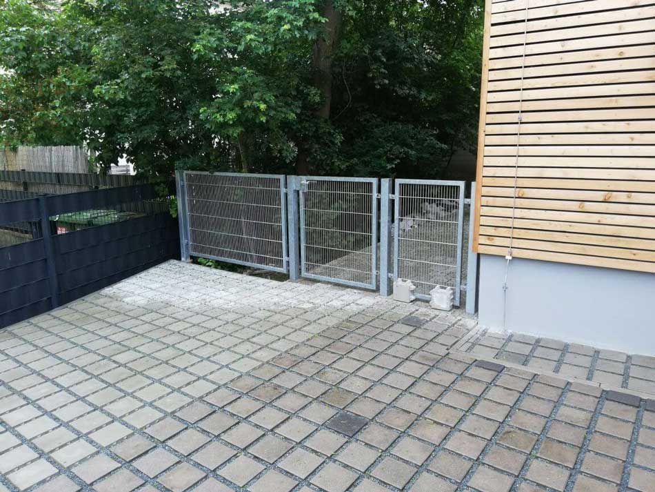 Zaun mit Tor an einem Gebäude