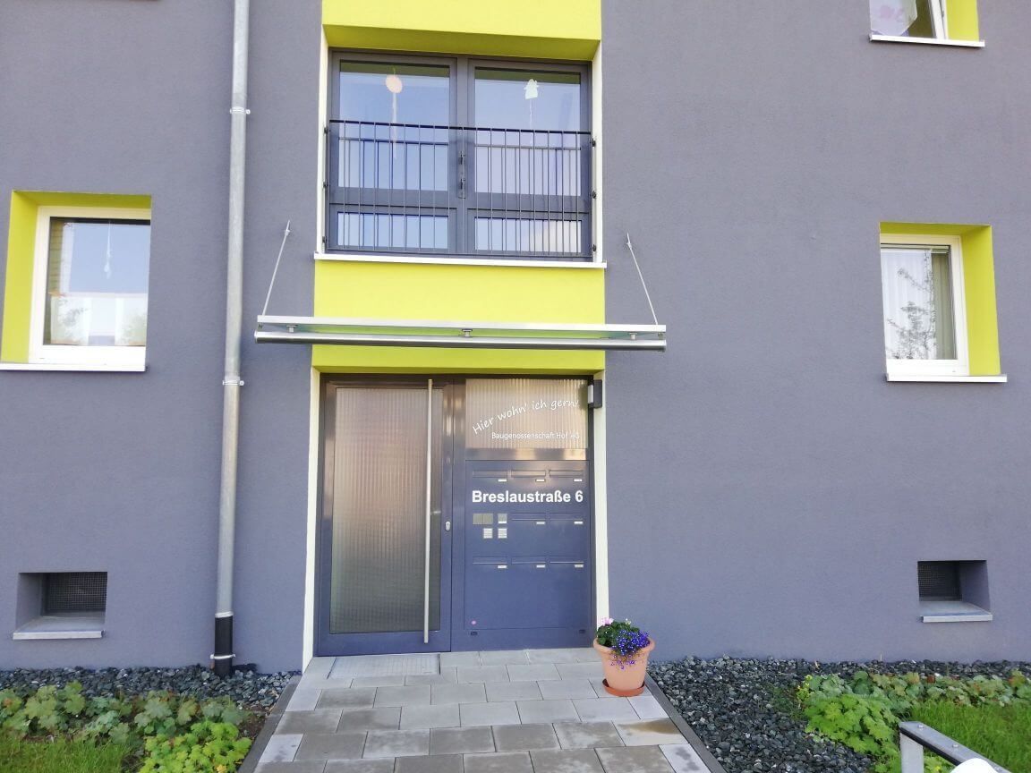 Vordach an einem Wohnungsgebäude aus Metall und Glas