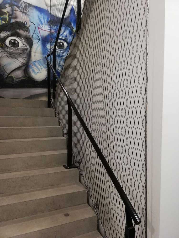Treppe mit Metallgeländer und Netz