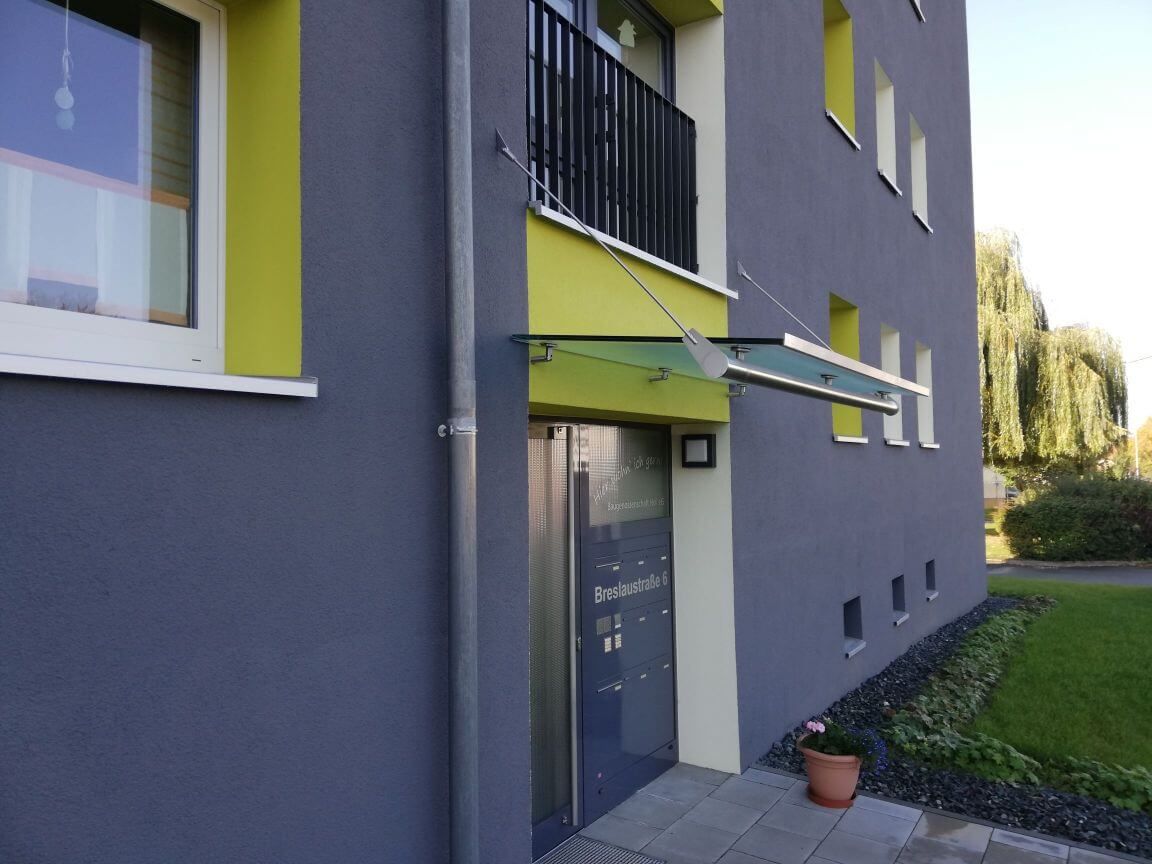 Eingangs-Überdachung eines Wohnungsgebäudes aus Metall und Glas