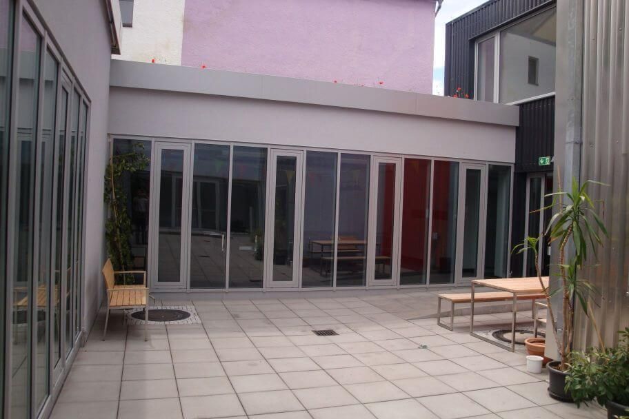 Fassade aus Metall und Glas an einem Durchgang zwischen zwei Gebäuden