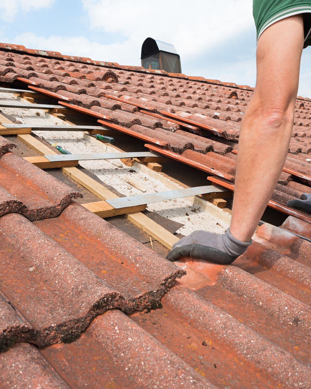Toit en tuiles d'argile, avec des lattes de bois apparentes et des solins métalliques.