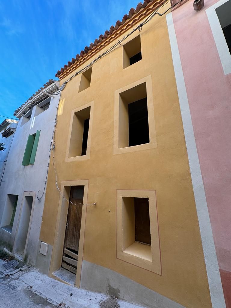 Système de gouttières grises sur le bord d'un bâtiment contre un ciel nuageux.