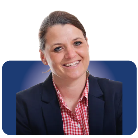 Lächelnde Frau in einem marineblauen Blazer und einem rot-karierten Hemd vor blauem Hintergrund