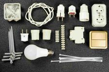 Dispersos componentes y herramientas eléctricas sobre una superficie oscura.