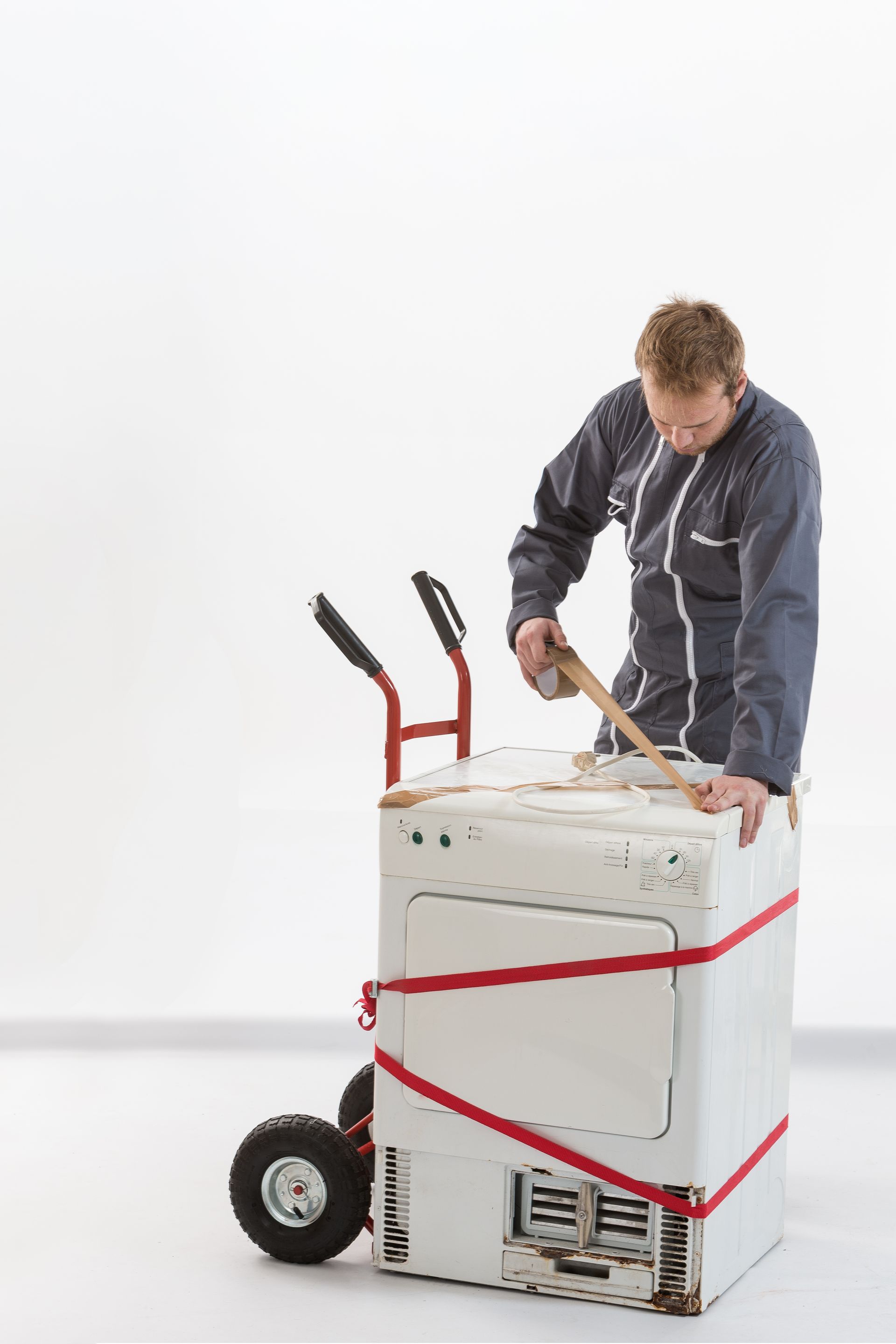 Un technicien apporte le sèche-linge à l'atelier pour une réparation
