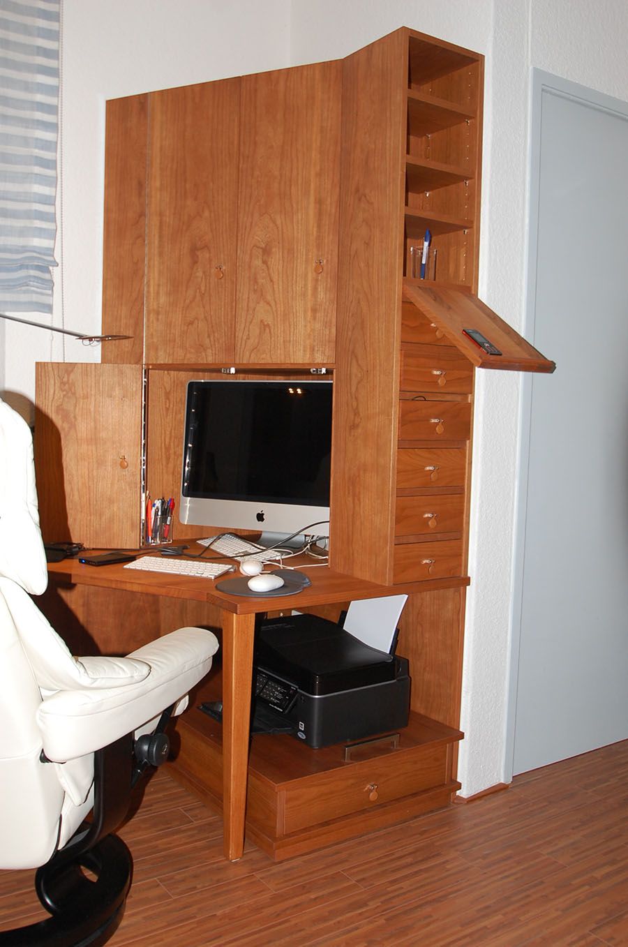 Ein Holzschreibtisch mit einem Computer und einem Drucker darauf