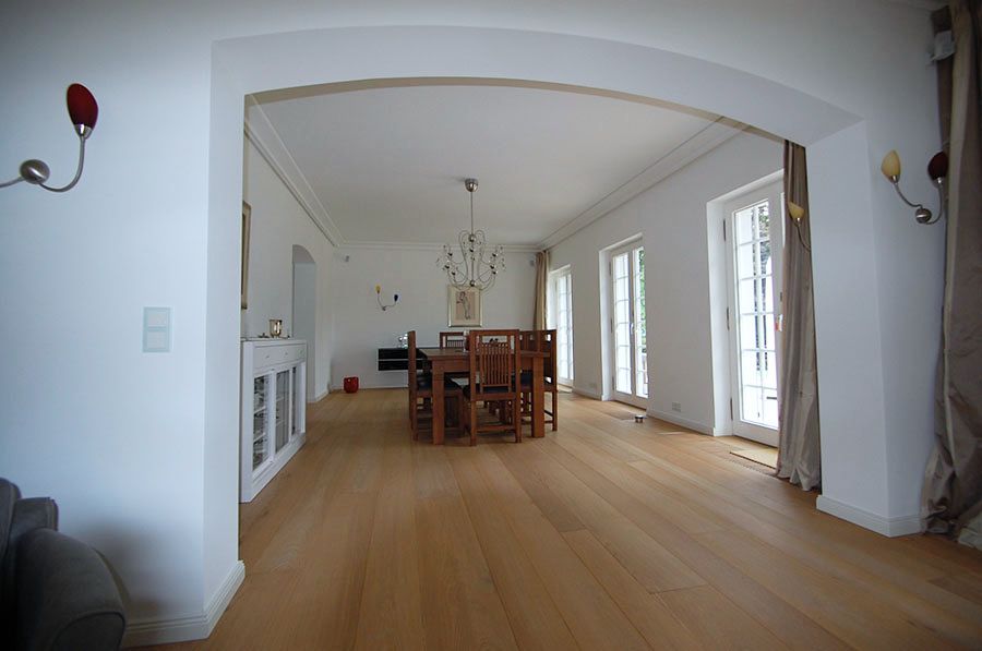 Esszimmer mit großem Esstisch und Stühlen aus dunklem Holz