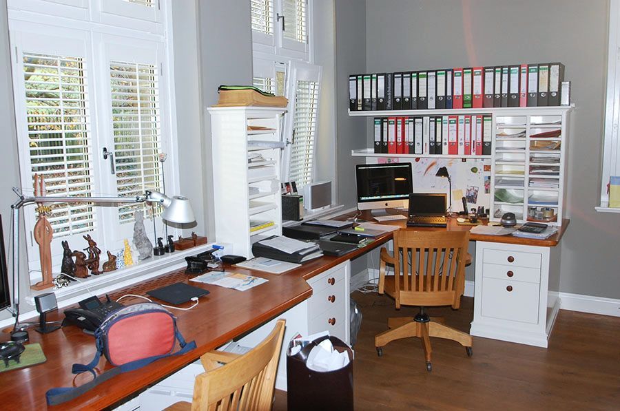 Arbeitszimmer/Büro mit einem langen Schreibtisch mit Schränken und Regalen