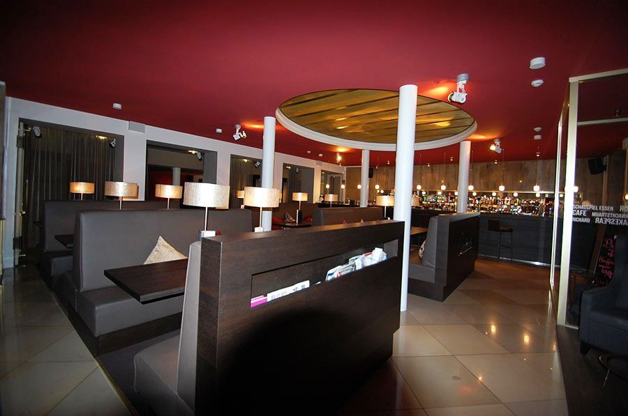 Inneneinrichtung in einem Restaurant mit roter Decke, schwarzen Bänken und Tischen