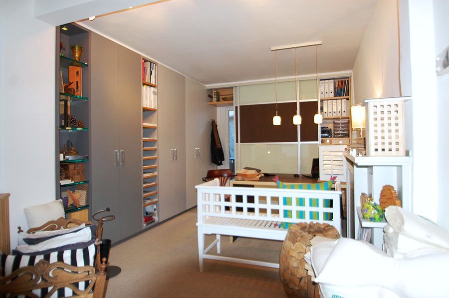 Links ein Einbauschrank, mittig eine weiße Sitzbank mit einem Tisch und im Hintergrund befindet sich ein Durchgang