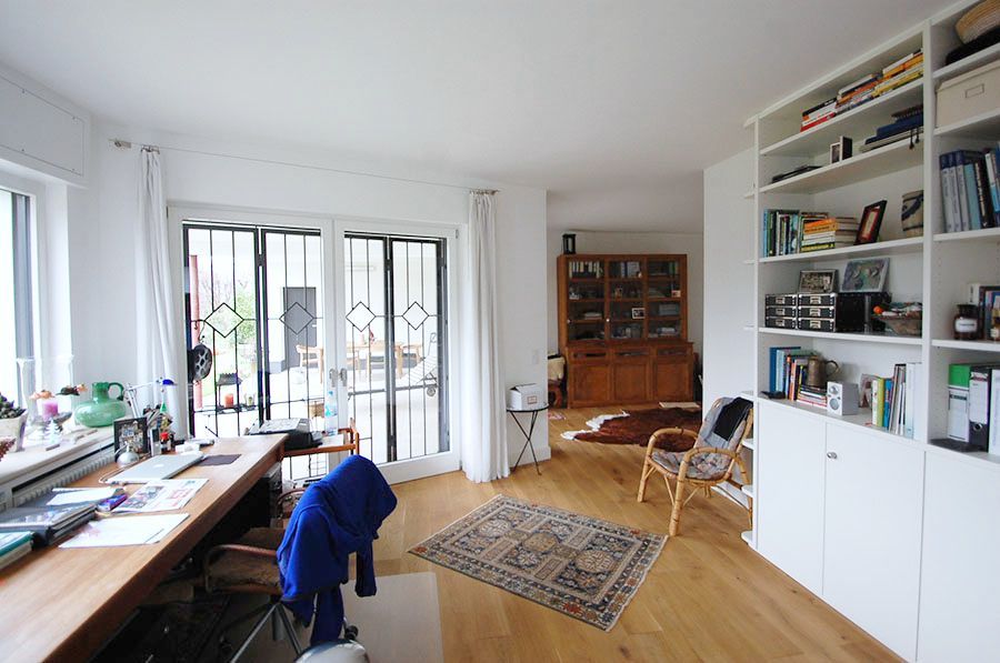 Raum mit einem Schreibtisch, Terassendoppeltür, Einbauschränken und Dekoration