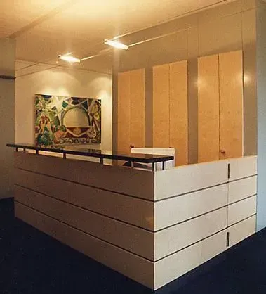 Empfangstheke im Generalkonsulat in Düsseldorf. Ahornholz, Sichtfugen mit Edelstahl, Thekenauflage aus schwarzem Granit