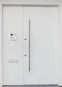 Haustür in weißmatt mit Edelstahlbeschlägen sowie integrierter Ruf- und Überwachungsanlage von Siedle.