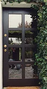 Hauseingangstür aus Kieferholz, Sprossenbauweise, außen dunkel lackiert, innen naturbelassen.