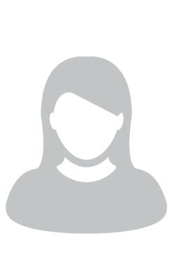 Eine Frau mit langen Haaren trägt ein blaues Hemd und lächelt.