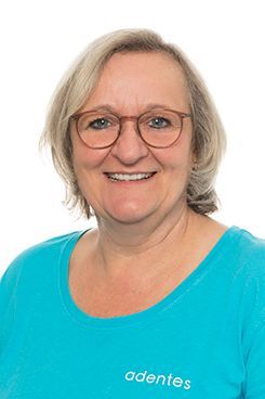 Verwaltungsangestellte Marina Eine Frau mit Brille und blauem Hemd lächelt in die Kamera.