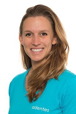 Physiotherapeutin Clara Eine Frau in einem blauen Hemd lächelt in die Kamera.