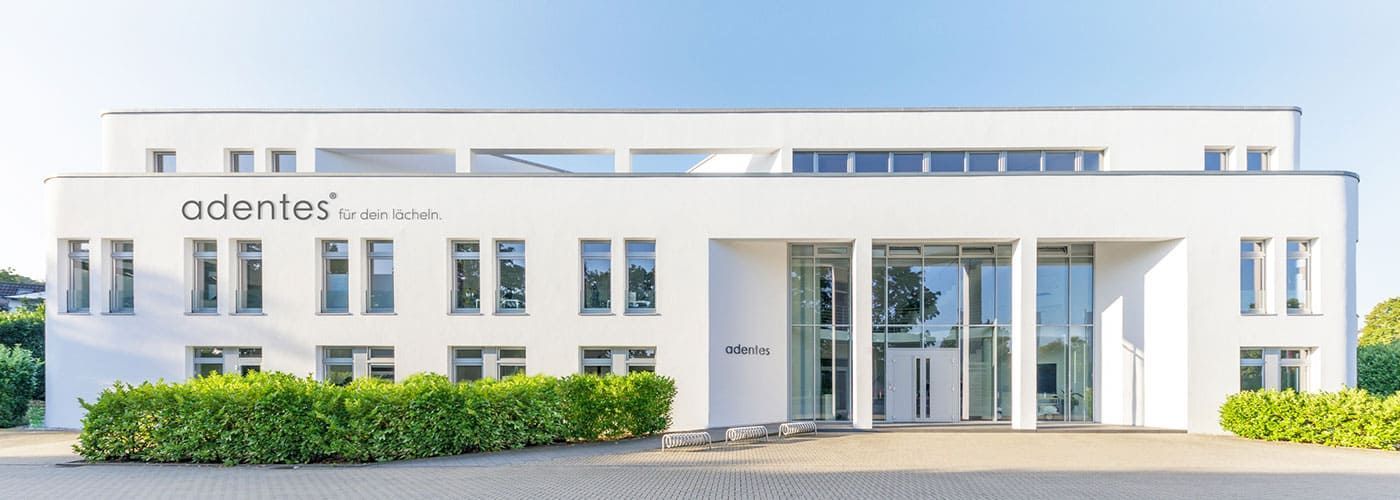 Jobs bei adentes Zahnarzt und MVZ in St. Augustin Ein großes weißes Gebäude mit dem Wort Atlantis auf der Spitze