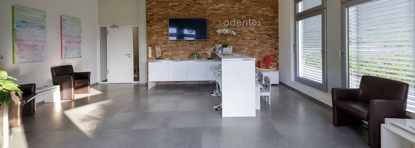 Kontakt zu adentes Zahnärzte und MVZ in Sankt Augustin Ein Wartezimmer mit Stühlen und einem Fernseher an der Wand