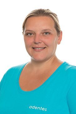 Zahnmedizinische Prophylaxeassistentin Jessica Die Frau trägt ein blaues Hemd und lächelt in die Kamera.