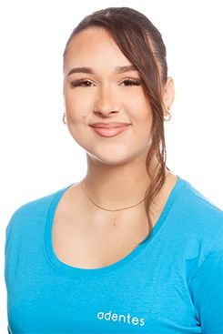 Eine Frau mit roten Haaren trägt ein blaues Hemd und lächelt.