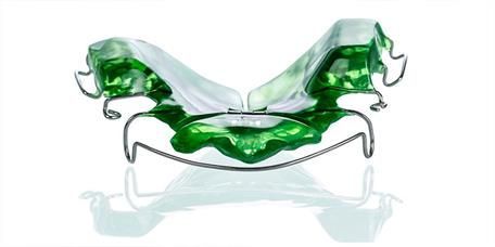 Ein grüner Zahnhalter liegt auf einer weißen Oberfläche.