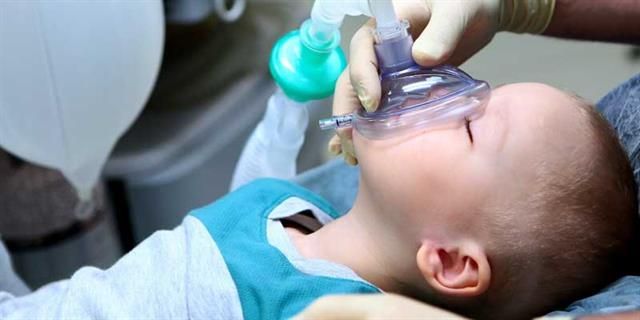 Ein Baby trägt eine Sauerstoffmaske auf dem Gesicht.