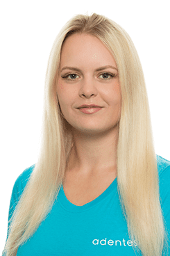 Zahnmedizinische Fachangestellte Julia Eine Frau mit langen blonden Haaren trägt ein blaues T-Shirt mit der Aufschrift „Adentes“.