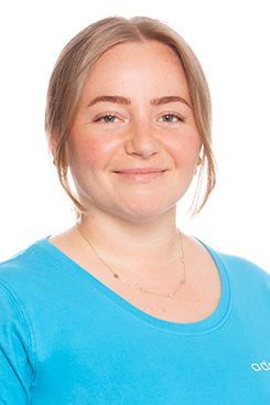 Zahnmedizinische Prophylaxeassistentin Jessica Die Frau trägt ein blaues Hemd und lächelt in die Kamera.