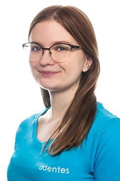 Assistenz Leonie Eine Frau mit Brille und blauem Hemd lächelt in die Kamera.